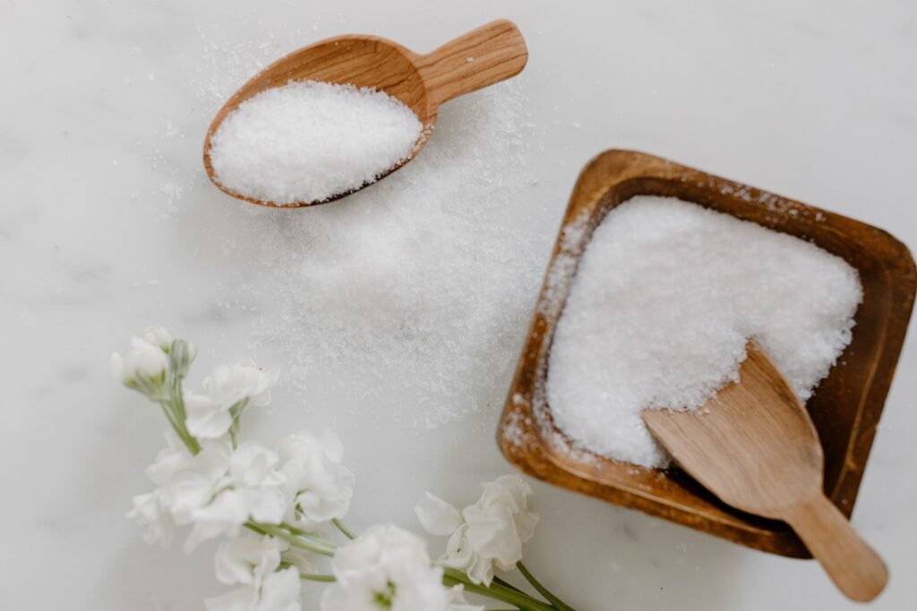 Sais de banho em potes e colheres de madeira.