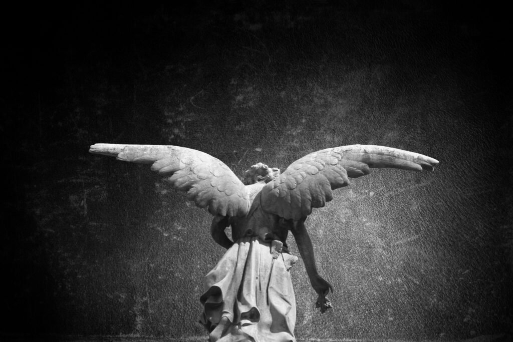Sombra de uma estátua de um anjo em preto branco.