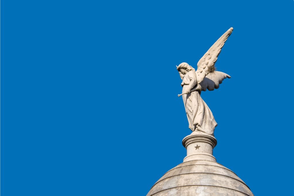 Estátua de anjo com um fundo de céu azul.