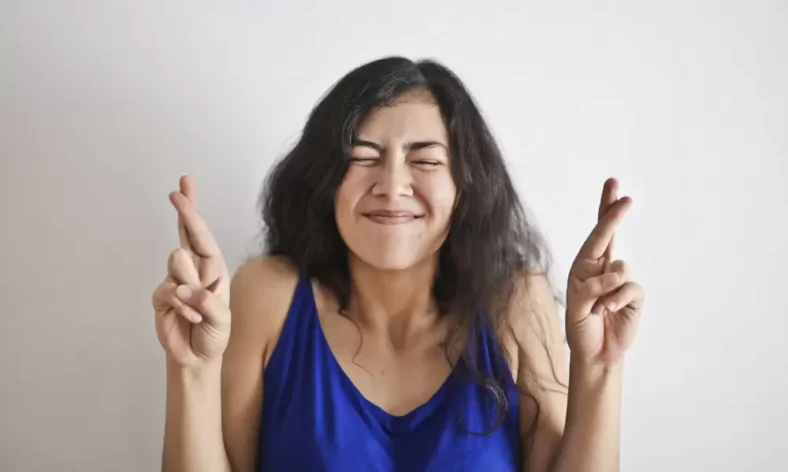 Mulher cruzando os dedos.